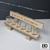 Small benches with shot glasses, various sayings